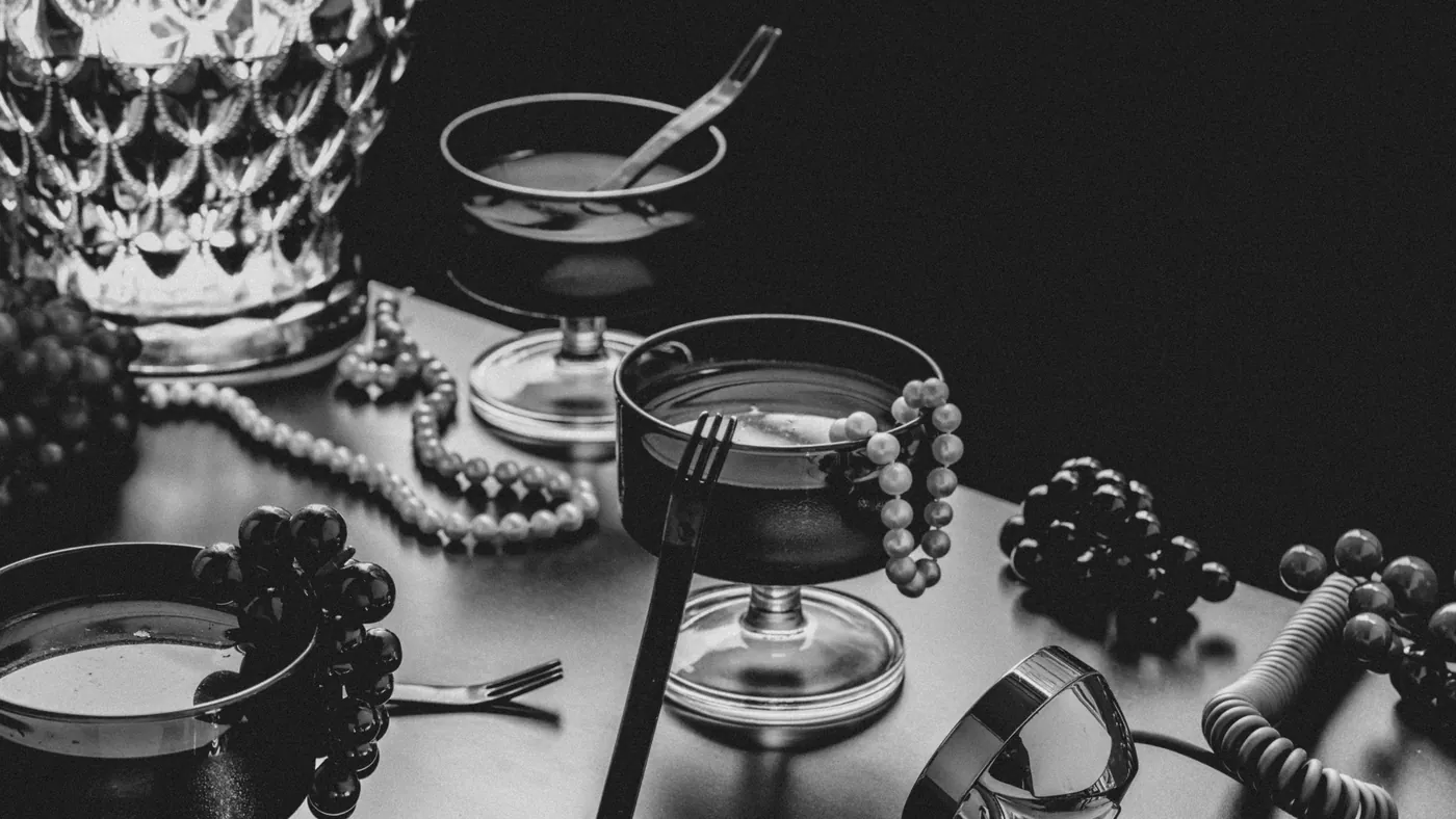 Coupes, pearls and grapes on a dark table