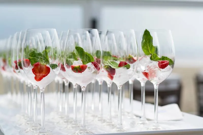 Rows of wine glasses with strawberries and mint